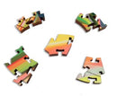 Colorful jigsaw puzzle pieces from the Sunset On Old Montauk Highway by Grant Haffner. The pieces feature vibrant patterns of orange, green, and yellow, showcasing a scenic sunset theme.