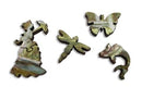 Close-up of four unique jigsaw puzzle pieces from the Monet Bridge puzzle by Artifact Wooden Puzzles. The pieces feature intricate designs including a woman with an umbrella, a butterfly, a dragonfly, and a fish, showcasing vibrant colors inspired by Monet's artwork.