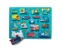 A colorful wooden jigsaw puzzle featuring various vehicles including cars, trucks, boats, a train, and construction equipment, arranged on a bright turquoise background. The puzzle pieces are intricately designed with playful illustrations and icons related to transportation.