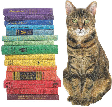 A colorful jigsaw puzzle featuring a stacked collection of books in vibrant hues on the left and a detailed image of a sitting tabby cat on the right. The puzzle combines elements of reading and pets, providing an engaging activity for cat lovers and puzzle enthusiasts alike.