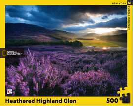 The Heathered Highland Glen Puzzle is a 500-piece jigsaw puzzle featuring a stunning landscape of purple heather fields under a dramatic sky. This scene showcases the beauty of nature, capturing lush greenery and serene valleys. Ideal for puzzle enthusiasts, this puzzle offers a relaxing challenge and a rewarding experience when completed.