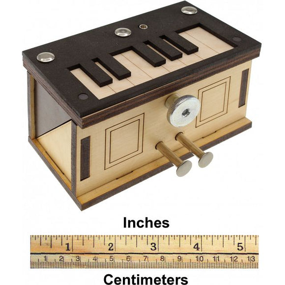 A beautifully crafted wooden mechanical puzzle called 'Piano Box' by Jean-Claude Constantin. The box features a keyboard design on top with various shapes, a shiny knob, and two metal pulls on the front. It is intricately designed for puzzle enthusiasts who enjoy mechanical challenges.
