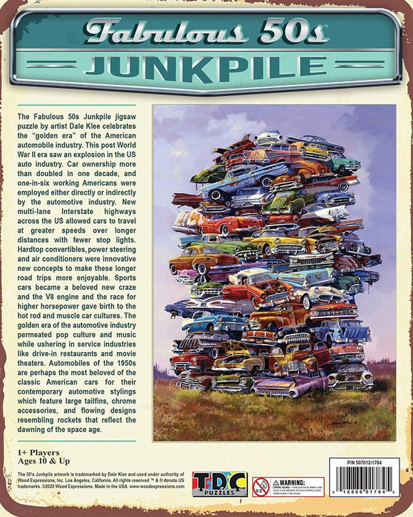 The Fabulous 50s Junkpile jigsaw puzzle features a colorful illustration of a towering junkpile consisting of classic American cars from the 1950s. The artwork celebrates the golden age of the American automobile industry, showcasing various models stacked high against a simple natural background. The puzzle is designed to engage users in a nostalgic experience of car culture in the post-World War II era.