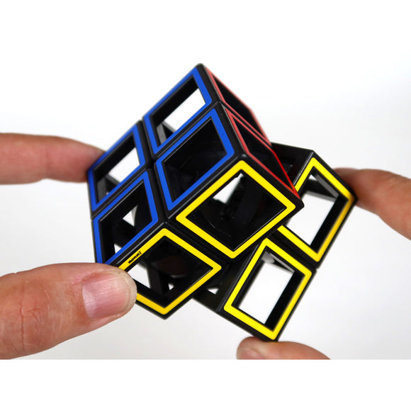 A person’s hands manipulate a Hollow Cube - Two By Two mechanical puzzle by RT18. The puzzle features vibrant colors including red, blue, yellow, and black, showcasing a unique hollow design that challenges spatial reasoning and problem-solving skills.