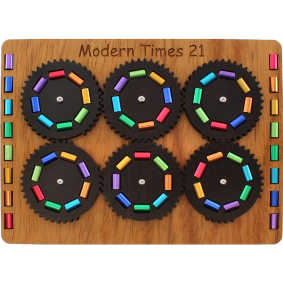 A mechanical puzzle titled 'Modern Times 21 - 6X' by Jean-Claude Constantin. The puzzle features six interlocking gears arranged on a wooden base, each adorned with colorful rectangular pieces. The gears are designed to rotate, creating an engaging challenge for puzzle enthusiasts. The wood surface is polished, enhancing the aesthetic appeal of the puzzle, which invites creative problem-solving and entertainment.