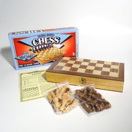 A 12-inch folding wooden chess set by House of Marbles. The set includes a beautifully designed chessboard with a wood finish and a compartment for storing chess pieces. The box features vibrant graphics, stating 'Folding Wooden Chess' and highlighting it as 'The Classic Game'. There are two bags of chess pieces in light and dark wood tones, and a game instruction sheet is also visible.
