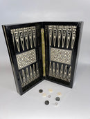 A beautifully crafted 12-inch Backgammon board featuring mother-of-pearl inlays. The board is opened and displays intricate geometric patterns. Several gaming pieces and dice are positioned around the board on a smooth, neutral background.
