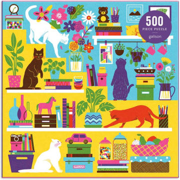 A vibrant jigsaw puzzle titled 'Curious Cats' by Galison, featuring a colorful illustration of various cats exploring a lively room filled with books, plants, and vibrant decor. The puzzle consists of 500 pieces, showcasing a whimsical and playful design that captures the curiosity of cats amidst an organized chaos.