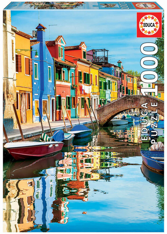 Burano jigsaw puzzle by Educa featuring a colorful canal scene with vibrant houses reflecting in the water, showcasing a picturesque view of Burano, Italy. The puzzle contains 1000 pieces, perfect for both beginners and experienced puzzlers.