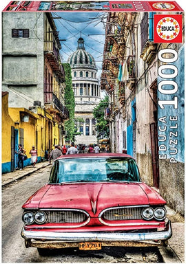 Educa Vintage Car in Old Havana jigsaw puzzle featuring a classic red car parked on a narrow street flanked by colorful buildings, with the Havana skyline in the background.