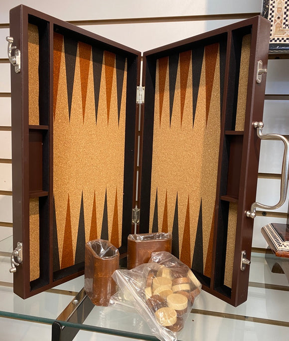 A beautifully crafted 15-inch Backgammon set with a wooden case featuring a cork playing surface. The game includes assorted checkers and dice with a sleek, modern design suitable for elegant entertainment. The board displays a vibrant pattern with alternating shades of brown and black, enhancing the gaming experience.