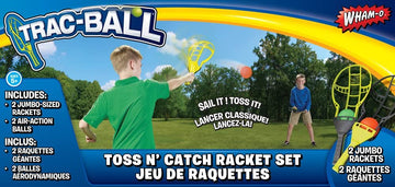 The Trac Ball Set by WHAM-O features two jumbo-sized rackets and two air-action balls. In the background, children are playing with the rackets in a grassy area, showcasing an engaging outdoor game perfect for ages 5 and up. The packaging highlights its fun and interactive play style, encouraging friends and family to join in on the excitement.