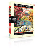 The Fall Planting Puzzle by New York Puzzle Company features a vibrant scene of a gardener planting in a colorful autumn landscape. The 1000-piece jigsaw puzzle comes in a decorative box showcasing the artwork by Pierre Brissaud, highlighting fall foliage and garden elements.