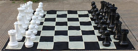 Large outdoor chess set featuring a garden size 16-inch king piece. The chessboard is designed with alternating black and white squares, and the pieces are arranged in two color groups: classic white and bold black. Ideal for backyard or garden play, this set offers a fun and engaging way to enjoy chess outdoors.