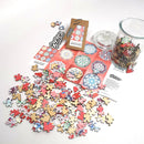 A colorful jigsaw puzzle titled '9 Mandalas' made by Trove, featuring an assortment of intricately designed wooden pieces in various shapes and colors. The scattered puzzle pieces are shown alongside a packaging card and a glass jar filled with additional pieces, all against a white background. The puzzle promises a creative and engaging activity for puzzle enthusiasts.