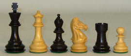 A display of black and boxwood chess pieces, each measuring 3.75 inches high. The set includes a black king and queen, a boxwood king and queen, a black knight, a boxwood rook, and a boxwood pawn, all exquisitely crafted with a classic design and double weighting for stability during play.