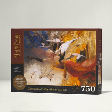 Art & Fable Puzzle Co's 'Transcendent Migration' jigsaw puzzle box featuring vibrant artwork by Julie Bell. The box shows a scene with a graceful woman surrounded by birds in flight, evoking a sense of movement and beauty. The puzzle contains 750 pieces and features a velvet touch surface for an enhanced tactile experience.