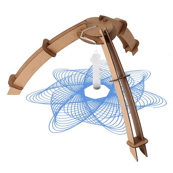 Kikkerland Make Your Own Painting Pendulum DIY kit, featuring a wooden structure with curved arms, a hanging pendulum, and beautiful blue spirals drawn on paper underneath. This creative kit allows users to explore art and science by creating unique pendulum paintings.