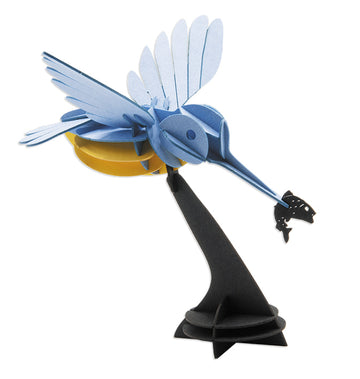 A colorful 3D paper model of a kingfisher in flight, featuring its beak extended towards a small fish. The model showcases intricate cut-out designs, with vibrant blue and yellow layers contrasted against a black base, making it a visually striking DIY project.