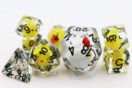 Set of RPG dice with transparent bodies. Each die contains a small yellow chicken figurine inside. The dice have black numbers and red accents.