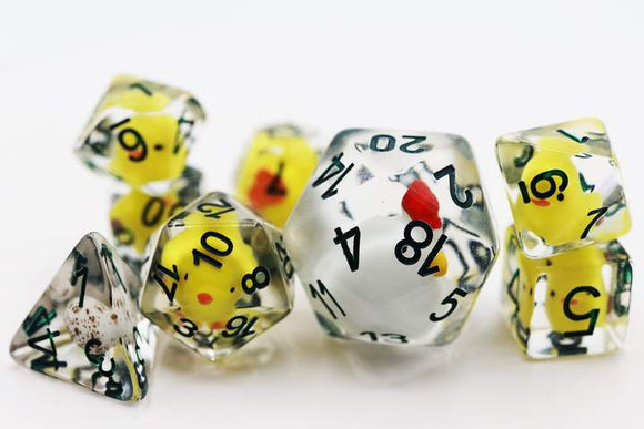 Set of RPG dice with transparent bodies. Each die contains a small yellow chicken figurine inside. The dice have black numbers and red accents.