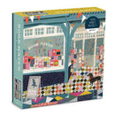 Book Haven jigsaw puzzle by Galison featuring a cozy bookstore scene with colorful book displays and a dog on a patterned floor. The puzzle contains 1000 pieces and showcases a vibrant, artistic design that invites relaxation and creativity.