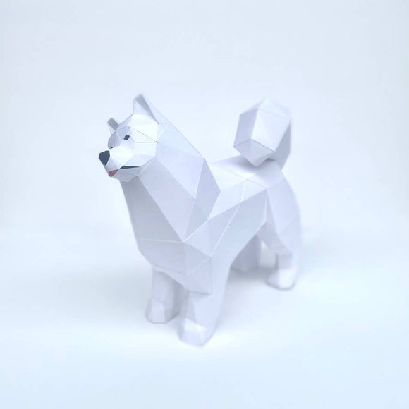 A detailed, geometric low poly standing model of a Samoyed dog crafted in white. The model showcases triangular facets, presenting a modern art style suitable for DIY enthusiasts and pet lovers.