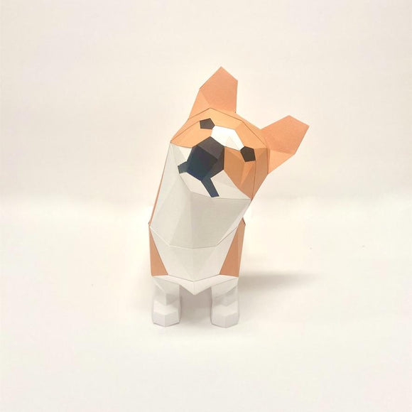 A cute standing model of a Corgi designed in low poly craft style. The model features geometric shapes with a warm orange and white color scheme, capturing the playful essence of the Corgi breed. It is fully assembled and stands upright on a plain background.