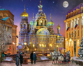 A beautifully illustrated jigsaw puzzle titled 'Russian Christmas' by Springbok, featuring a picturesque winter scene with a majestic cathedral adorned with colorful domes. The scene includes snow-covered trees, festive lights, and people strolling in a charming town square under a starry night sky with a full moon.