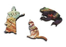Three wooden jigsaw puzzle pieces from the 'Dragon Mountain' puzzle by Bryn Barnard. The pieces feature colorful designs with a silhouette of a figure, a cat, and a dragon, showcasing intricate craftsmanship and vibrant artwork.