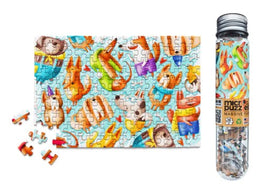 A completed 150-piece jigsaw puzzle titled 'Dog Gone It' featuring colorful illustrations of various playful dogs and cute characters on a light blue background. The puzzle pieces are small and are shown next to a transparent tube that contains additional puzzle pieces.