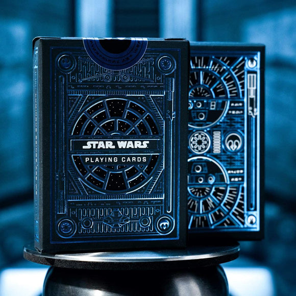 A beautifully designed Star Wars Light Side Card Deck by Theory 11. The deck features an intricate blue and black design, showcasing a starry night theme with elements resembling the iconic Star Wars franchise. The front of the box prominently displays 'Star Wars Playing Cards' against a space-themed background, and the cards inside are crafted for fans of the series who enjoy playing games.