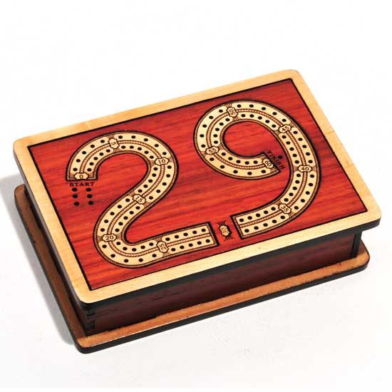 Wooden cribbage board designed with a 29-point scoring track and a sleek finish. Features a lid for storage and a stylish aesthetic, perfect for game nights.