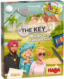 The Key: Murder at the Oakdale Club is a medium-level board game by HABA featuring colorful artwork. The box showcases three characters involved in a mystery at a golf club, with visual clues like a golf club, cart, and a crime scene outline in the background.