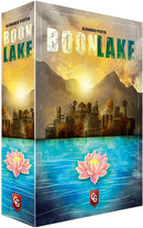 Boonlake board game box by Capstone Games featuring a serene lake scene with picturesque landscapes. The cover showcases a vibrant sunset with stylized buildings along the water's edge and beautiful pink lotus flowers in the foreground. The title 'BOONLAKE' is prominently displayed in bold letters.