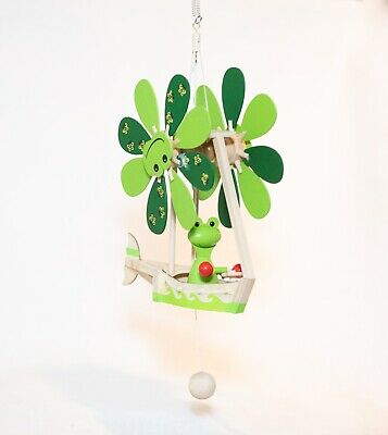 A whimsical Wupper Frog Boat hanging ornament featuring a cheerful frog pilot, green flower-shaped propellers, and a charming boat design. The decoration is made of colorful wood, perfect for adding a playful touch to any space.