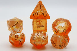 A vibrant Golden Koi Fish RPG Dice Set by Foam Brain. The dice are a mix of orange and yellow translucent resin with black numbering, showcasing a d20, d12, d10, d8, d6, and d4, beautifully stacked with intricate details reflecting light.
