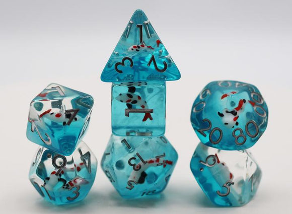 A colorful Water Garden Koi RPG Dice Set featuring translucent aqua dice with detailed koi fish embedded inside. The set includes various polyhedral dice, such as a pyramid, cube, and dodecahedron, each marked with numbers and striking red accents, ideal for tabletop gaming.