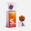 SPEKS Ignite Gradient, a magnetic fidget toy, displayed in its packaging. Features a vibrant ball made of small magnetic beads in warm colors, resting on a clear stand. The packaging is designed with bright orange and white colors, showcasing the product's name and slogan 'spectacularly magnetic.'
