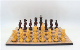 A beautifully crafted chess set featuring 5-inch king rosewood concentric ball chess pieces. The board displays alternating light and dark squares, with intricate and detailed carvings on the pieces, showcasing elegance and style. The set is arranged for an engaging game of chess, highlighting the thoughtful design and artistry of WorldWise Imports.