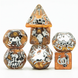 A vibrant Desert Bull Head RPG Dice Set by Foam Brain Dice featuring a unique design with amber and black colors. The set includes seven polyhedral dice, showcasing intricate numbers and illustrations, perfect for tabletop role-playing games.