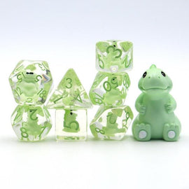 A whimsical Baby T Rex RPG Dice Set by Foam Brain, featuring five transparent polyhedral dice in shades of green with numbers displayed in vibrant green. The set includes a baby T-Rex figurine in a soft green color, adding a playful touch to the role-playing game accessories. The dice set is perfect for tabletop gaming enthusiasts looking to enhance their gaming experience.