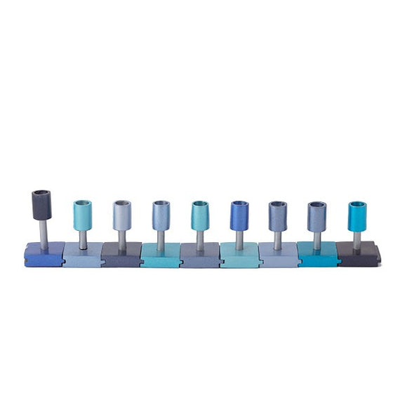 A beautifully designed Puzzle Menorah in blue shades featuring ten removable sections representing the menorah's candles. Each section is uniquely colored in shades of blue and gray, creating an artistic jigsaw puzzle that combines a traditional symbol with modern design. Perfect for festive occasions or as a unique decorative piece.