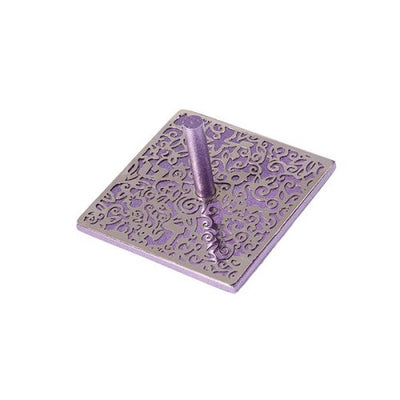 Purple laser cut dreidel intricately designed with swirling patterns. The eight-sided top is cylindrical, standing prominently on a square base, perfect for family games during Hanukkah.