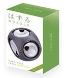 A close-up view of the Cast Dice mechanical puzzle by Hanayama. The puzzle features a sleek black design with shiny spherical elements. The packaging is vibrant green and white, displaying the product name 'CAST DICE' prominently on the front, along with a Japanese character that adds an artistic touch. The puzzle encourages problem-solving and is ideal for both beginners and experienced puzzlers.