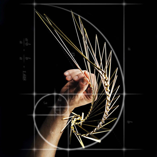 A close-up image of a hand manipulating an intricate golden structure resembling a mechanical puzzle, set against a dark background featuring geometric patterns and formulas. The design showcases a captivating blend of art and science, illustrating the harmony of aesthetics and engineering.