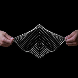 A person is holding the Square Wave Silver, a unique, interactive fidget toy made of flexible wire, forming a geometric, three-dimensional wave shape. The toy's intricate design allows for mesmerizing motion and manipulation, providing a soothing tactile experience.