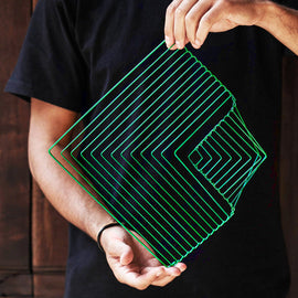 A person holding a square wave-shaped puzzle in emerald green, designed with multiple layers that create a unique visual pattern. The puzzle is crafted from sturdy material and showcases a modern geometric design, perfect for both decoration and entertainment.