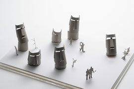 A detailed model of Easter Island featuring iconic moai statues, crafted from paper. The model includes various sizes of moai figures along with miniature human figures engaged in activities, all positioned on a flat base for display. The design showcases craftsmanship and intricate detailing, perfect for enthusiasts and collectors.