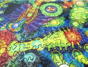 A vibrant and intricate jigsaw puzzle featuring an abstract design with swirling patterns and colorful spirals in shades of blue, green, yellow, and red. Each puzzle piece showcases unique interlocking shapes, inviting users to explore the artistic details as they assemble the full image. This jigsaw puzzle, titled 'Half Life' by Bruce Riley and made by Artifact Wooden Puzzles, offers a stimulating challenge for puzzle enthusiasts.